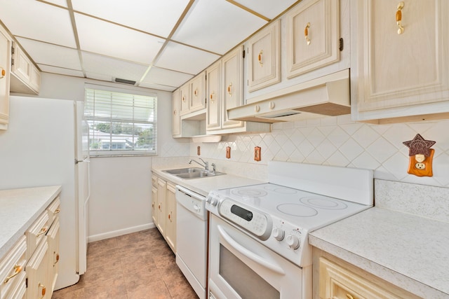 kitchen featuring decorative backsplash, light tile patterned floors, a paneled ceiling, sink, and white appliances