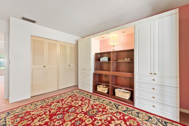 bedroom featuring a textured ceiling and carpet flooring