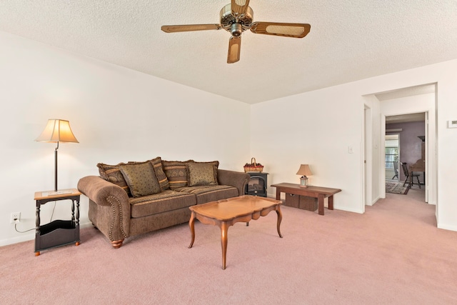 carpeted living room featuring ceiling fan and a textured ceiling