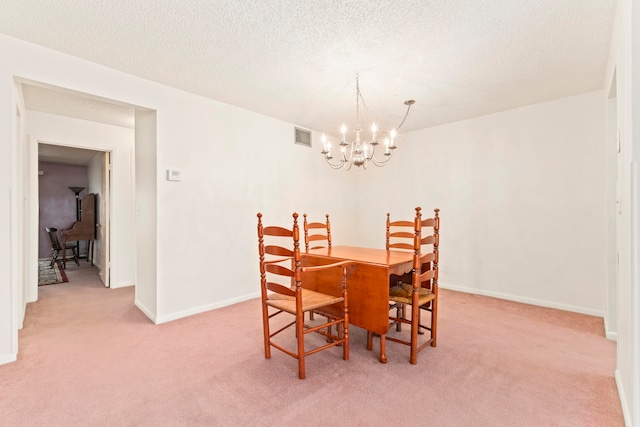 carpeted dining space featuring a textured ceiling and an inviting chandelier