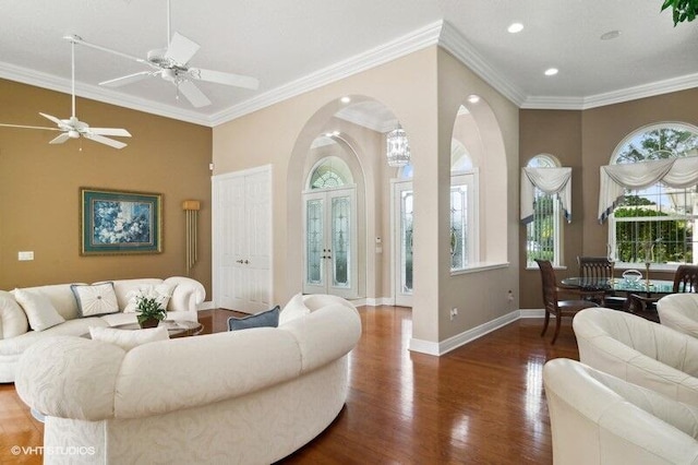 living room with dark wood-type flooring, ceiling fan, and ornamental molding