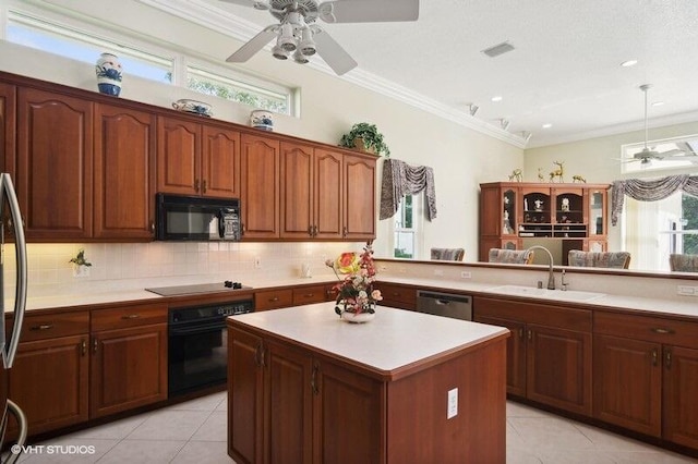 kitchen featuring kitchen peninsula, light tile patterned floors, black appliances, crown molding, and sink