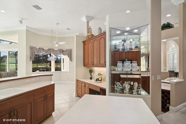 kitchen with crown molding, pendant lighting, light tile patterned floors, a textured ceiling, and ceiling fan