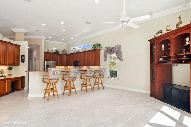 kitchen featuring light carpet, stainless steel fridge, ceiling fan, a breakfast bar, and ornamental molding