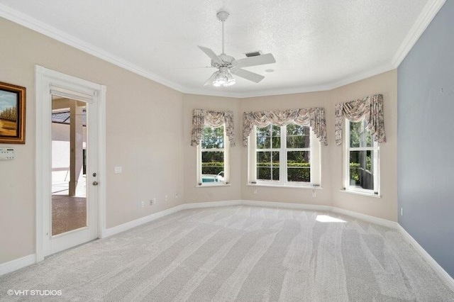 spare room with light carpet, ornamental molding, a textured ceiling, and ceiling fan