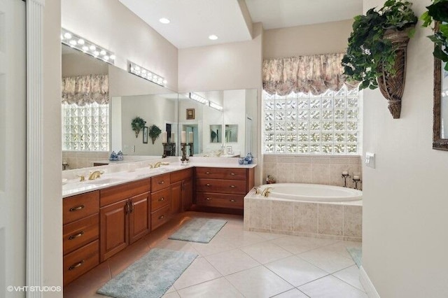 bathroom featuring vanity, a relaxing tiled tub, tile patterned floors, and a wealth of natural light