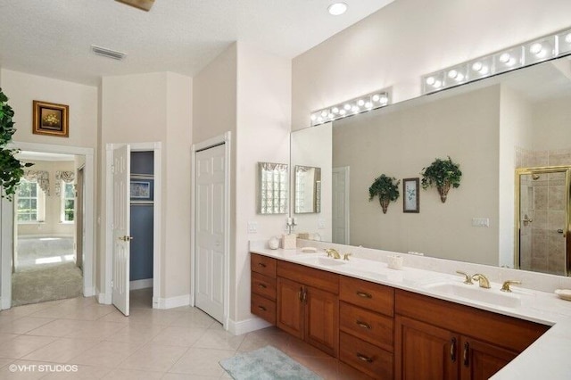 bathroom featuring vanity, tile patterned floors, and a shower with shower door