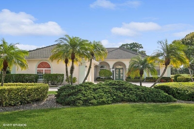 mediterranean / spanish home with a front yard