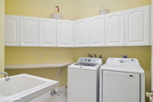 washroom featuring sink, washer and clothes dryer, and cabinets