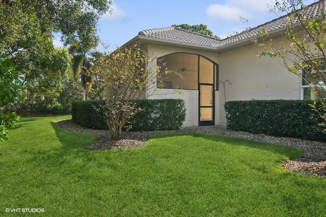 view of exterior entry featuring a yard