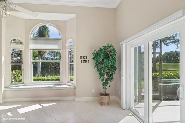 doorway to outside with crown molding, a healthy amount of sunlight, and light tile patterned floors