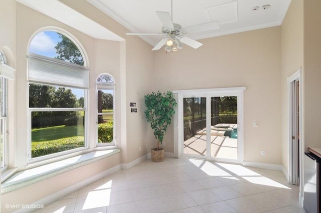 unfurnished sunroom featuring ceiling fan and a wealth of natural light