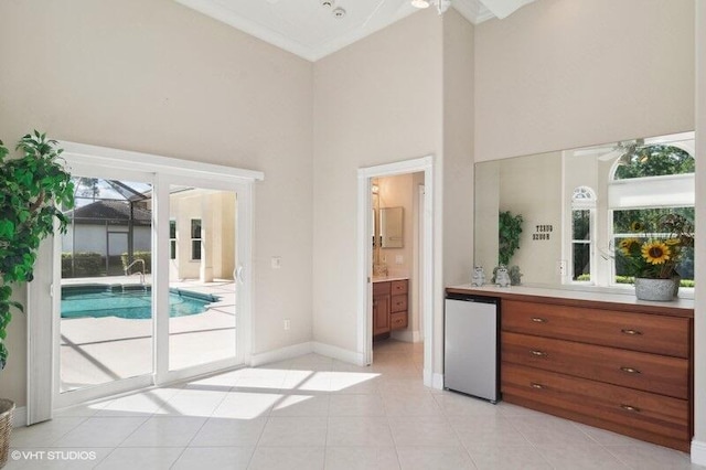 interior space featuring vanity, ceiling fan, a high ceiling, and tile patterned flooring