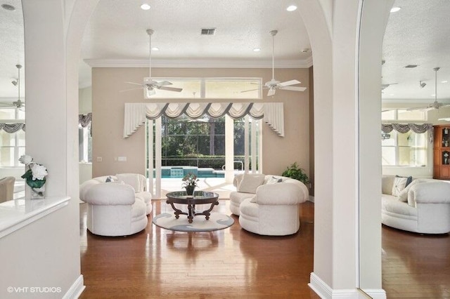 living room with dark wood-type flooring, a textured ceiling, and a healthy amount of sunlight