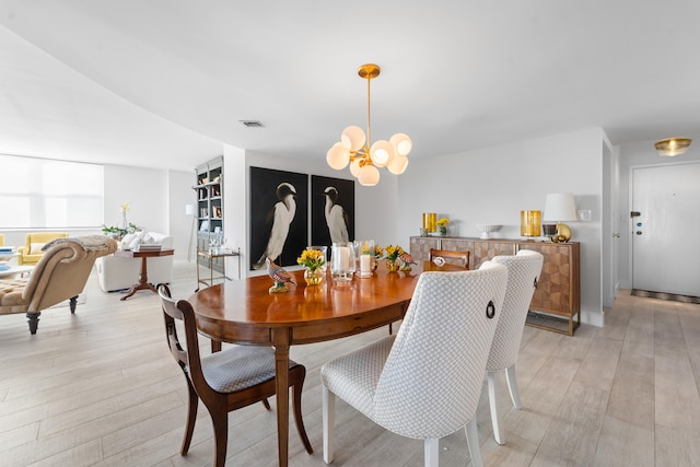 dining space with a chandelier and light wood-type flooring