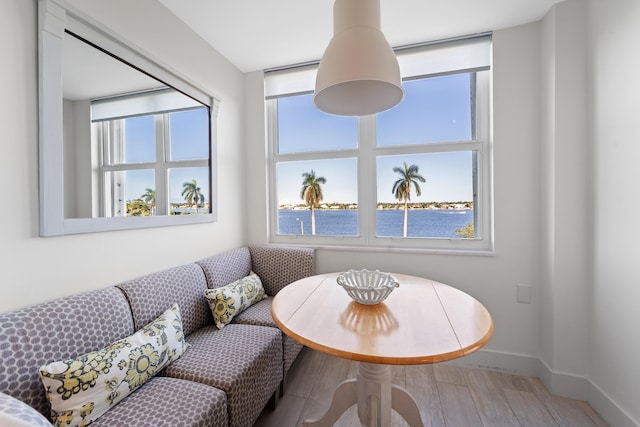 dining space featuring breakfast area, a water view, and hardwood / wood-style floors