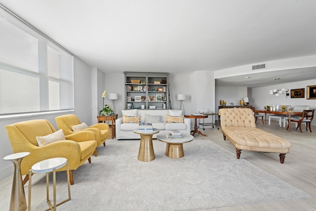 living room with light wood-type flooring and a chandelier