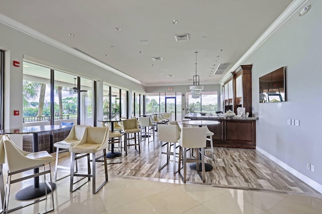 tiled dining space with crown molding and a healthy amount of sunlight