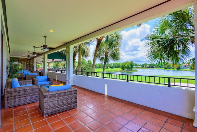 view of patio with outdoor lounge area, ceiling fan, and a water view