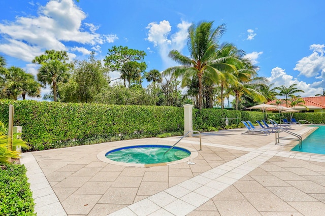 view of swimming pool with a community hot tub and a patio area