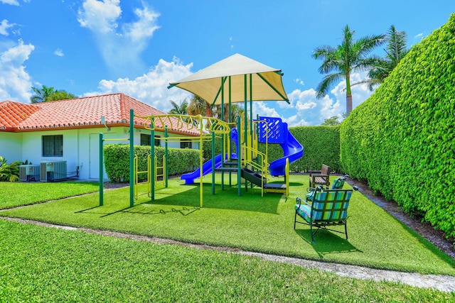 view of playground with a lawn and cooling unit