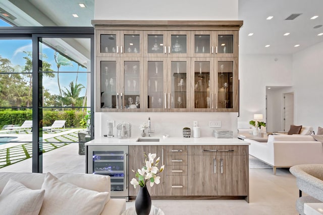 bar featuring tasteful backsplash, wine cooler, and sink