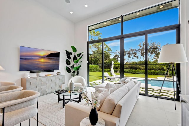 living room featuring light tile patterned flooring and a towering ceiling