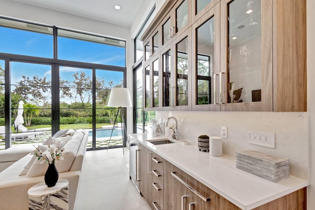 bar with light tile patterned flooring, sink, and tasteful backsplash