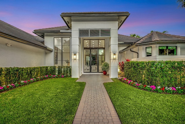 exterior entry at dusk with a lawn