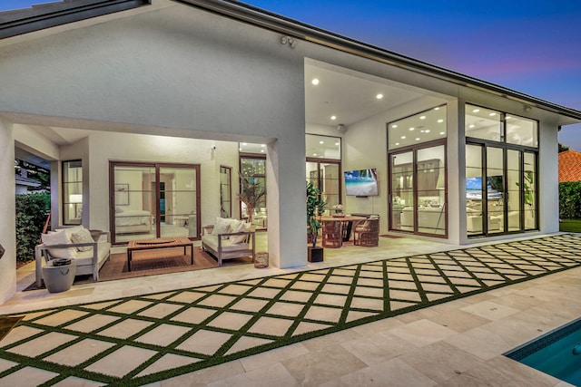 rear view of property with outdoor lounge area and a patio