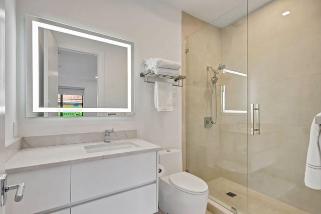 bathroom featuring vanity, toilet, and a shower with door