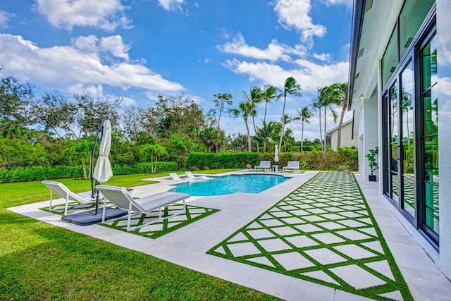 view of pool featuring a yard and a patio