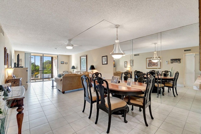 tiled dining space featuring a textured ceiling and ceiling fan