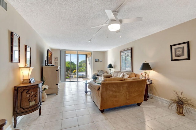 tiled living room with a textured ceiling and ceiling fan