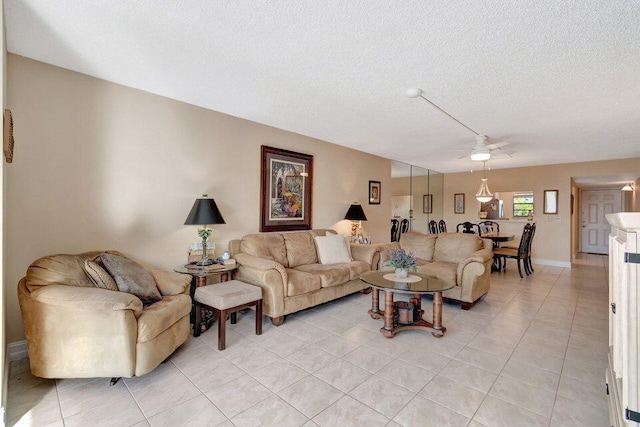 living room with a textured ceiling, light tile patterned floors, and ceiling fan