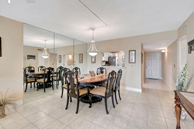 dining room with a textured ceiling and light tile patterned flooring