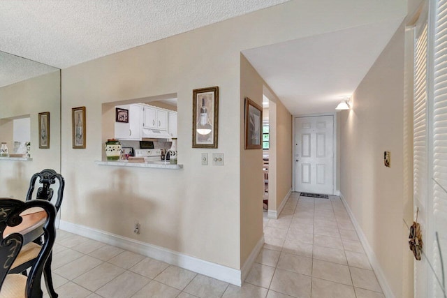 foyer entrance featuring light tile patterned flooring and a textured ceiling