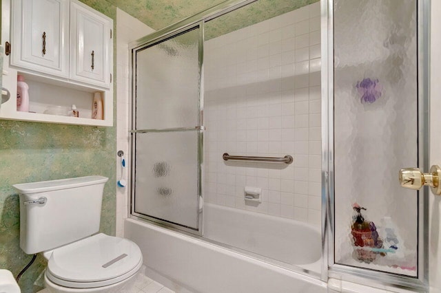 bathroom featuring enclosed tub / shower combo and toilet