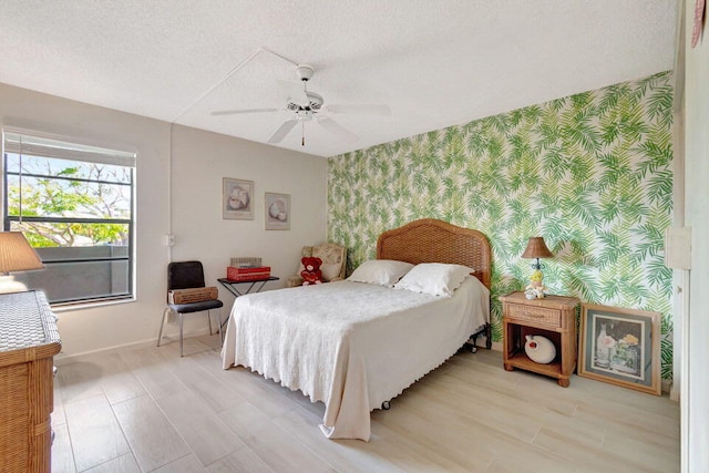 bedroom featuring ceiling fan, a textured ceiling, and light hardwood / wood-style flooring