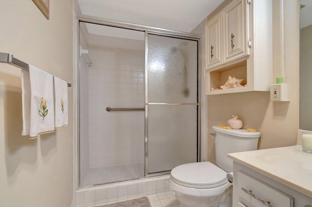 bathroom with toilet, a shower with shower door, vanity, and tile patterned floors