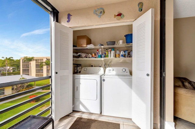 laundry area featuring washing machine and clothes dryer and light tile patterned floors