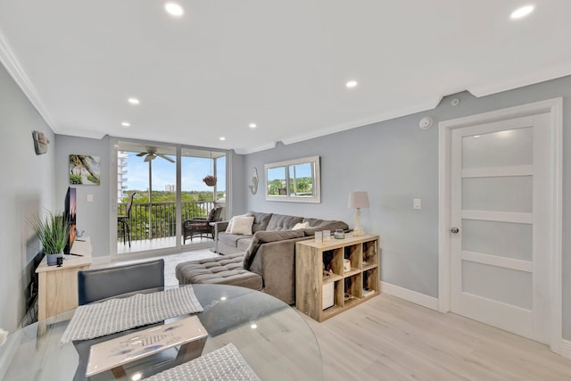 living room with ceiling fan, ornamental molding, and light hardwood / wood-style flooring