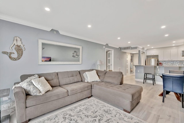 living room featuring crown molding and light hardwood / wood-style flooring