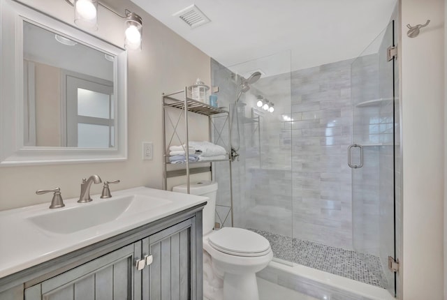 bathroom featuring vanity, toilet, and a shower with door