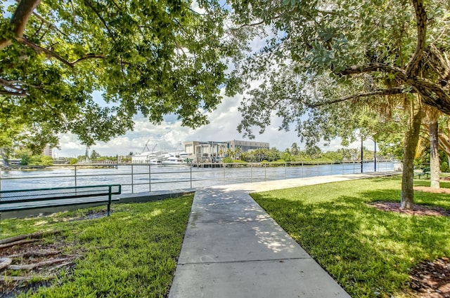 view of property's community with a yard and a water view