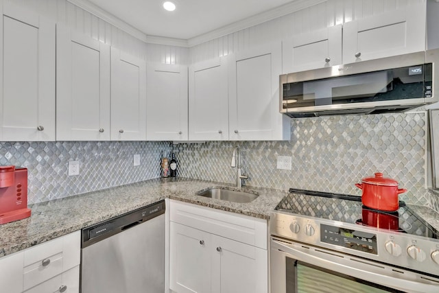 kitchen with sink, appliances with stainless steel finishes, white cabinetry, and tasteful backsplash