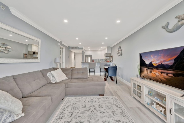 living room featuring ornamental molding and light hardwood / wood-style flooring