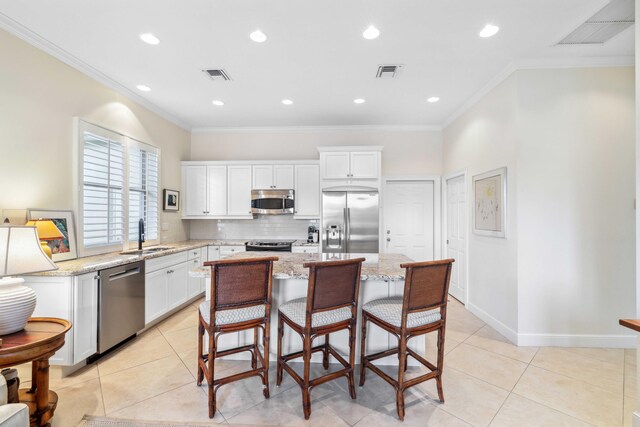 4 Country Rd, Village Of Golf, FL 33436 - kitchen with sink, light tile patterned floors, light stone countertops, appliances with stainless steel finishes, and a kitchen island
