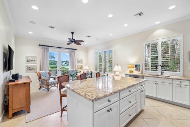 4 Country Rd, Village Of Golf, FL 33436 - kitchen featuring white cabinets, a kitchen island, light tile patterned flooring, and sink