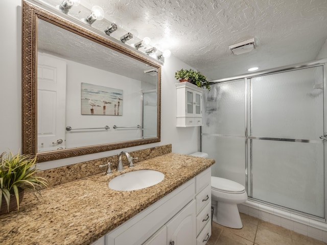 bathroom with tile patterned flooring, an enclosed shower, and a textured ceiling